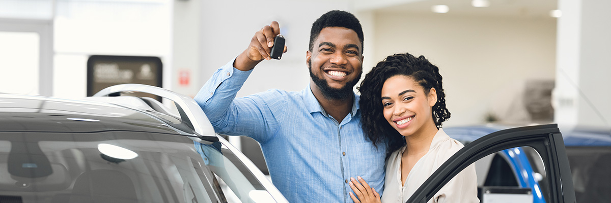 couple showing off keys to new car