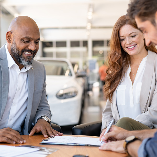 Dealership employee pointing to finance paperwork