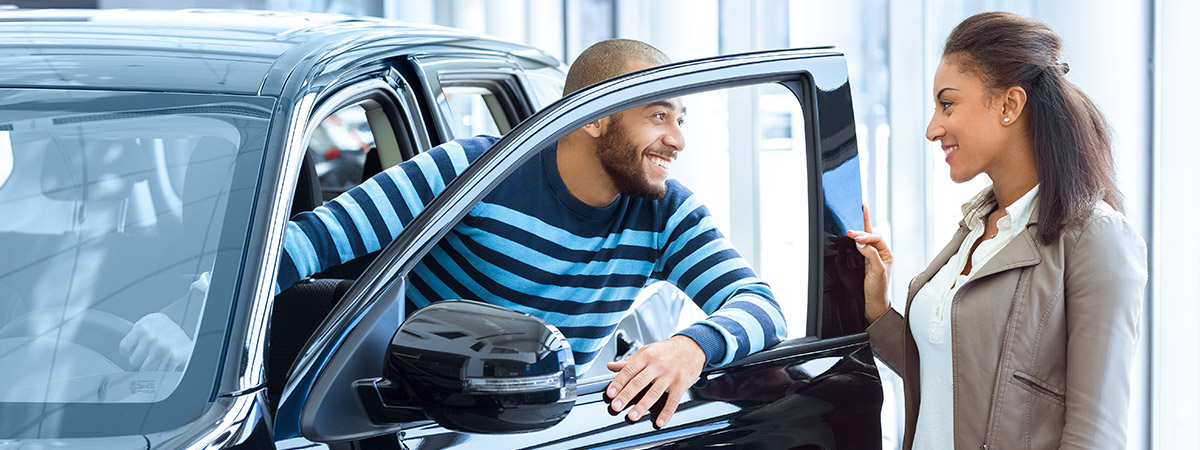 customer speaking with salesperson at a car dealership