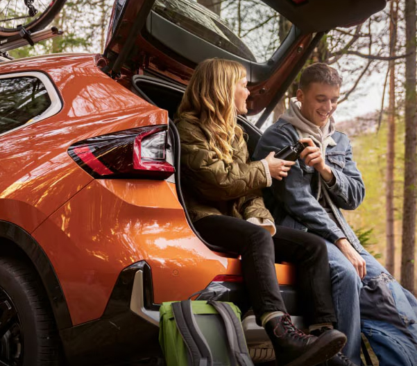 woman and young man sitting in back of a bmw