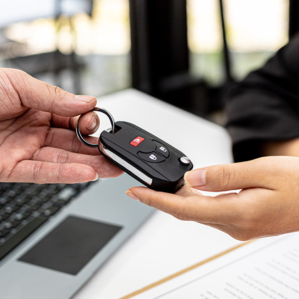 Car keys being handed from one person to another 