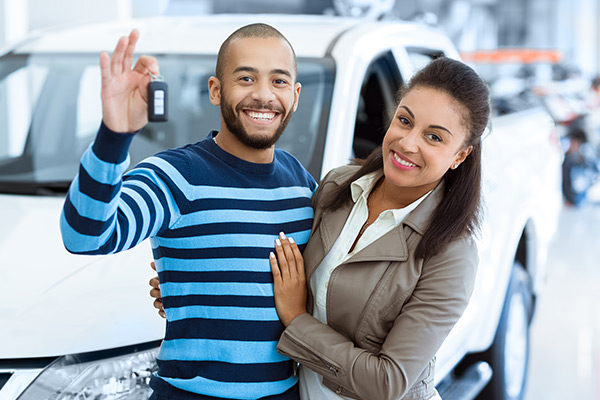 two happy people at car dealership