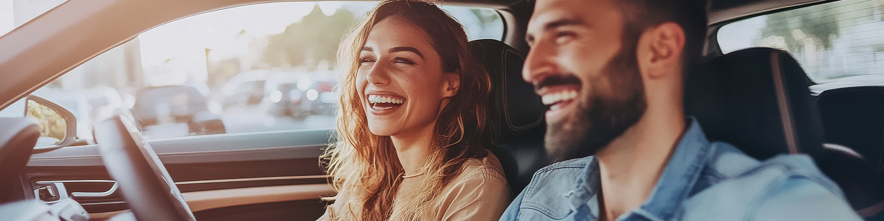 Young couple in a new car. A man driving a car with his girlfriend and having fun.