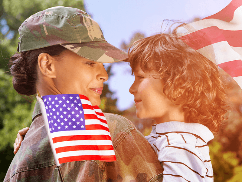 Military woman holding son and American flag