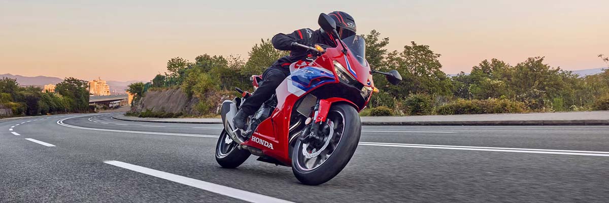 Honda motorcycle driving on highway at sunset