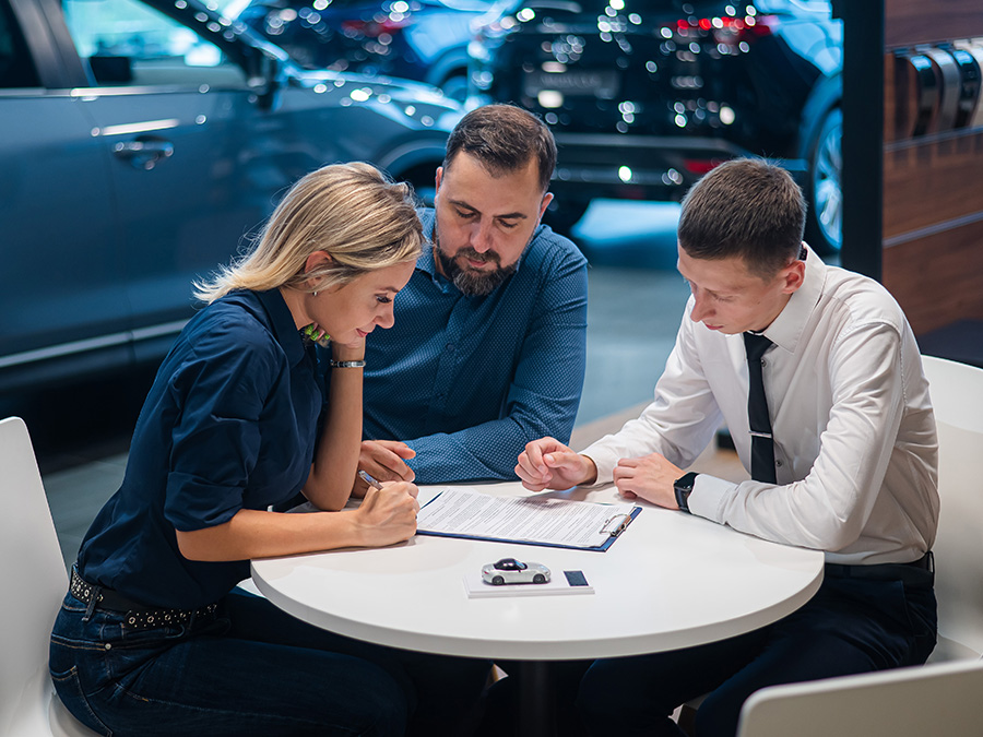 Dealership employee pointing to finance paperwork
