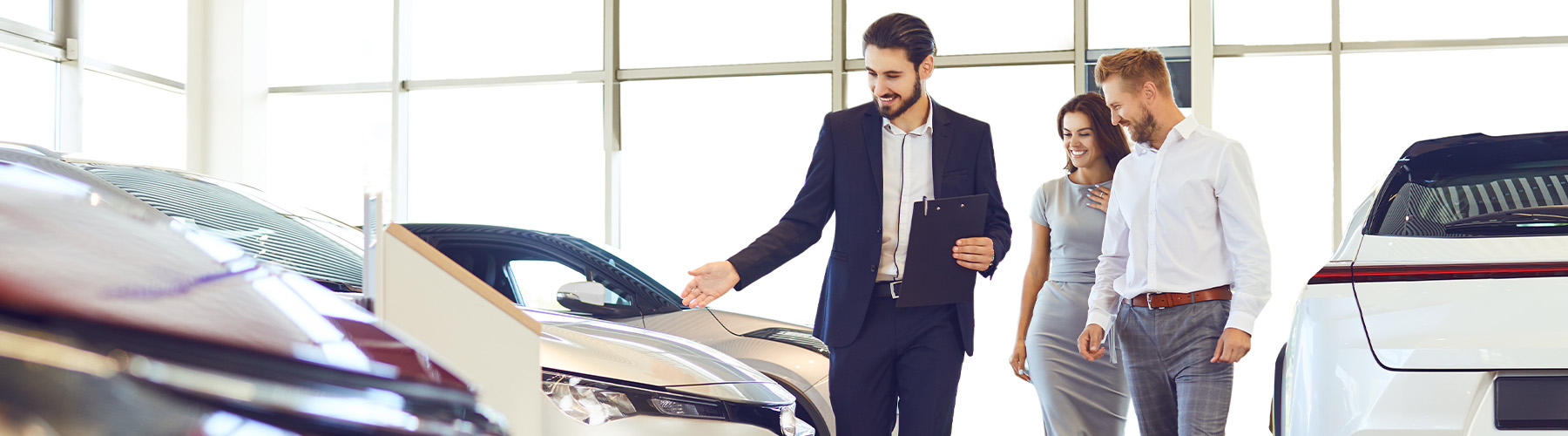 Dealership employee showing a couple a vehicle in the showroom
