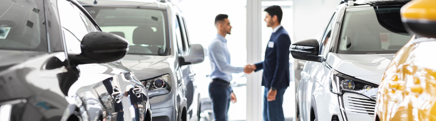 Dealership employee showing a couple a vehicle in the showroom