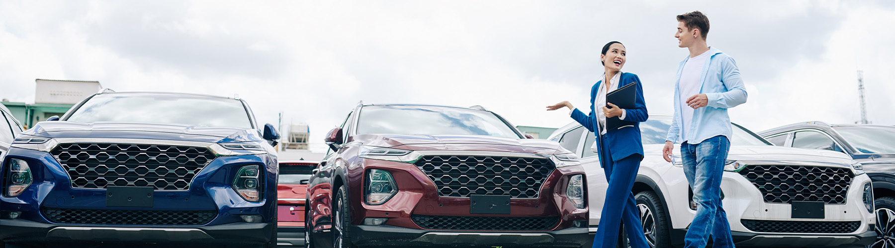 Dealership employee showing a couple a vehicle in the showroom