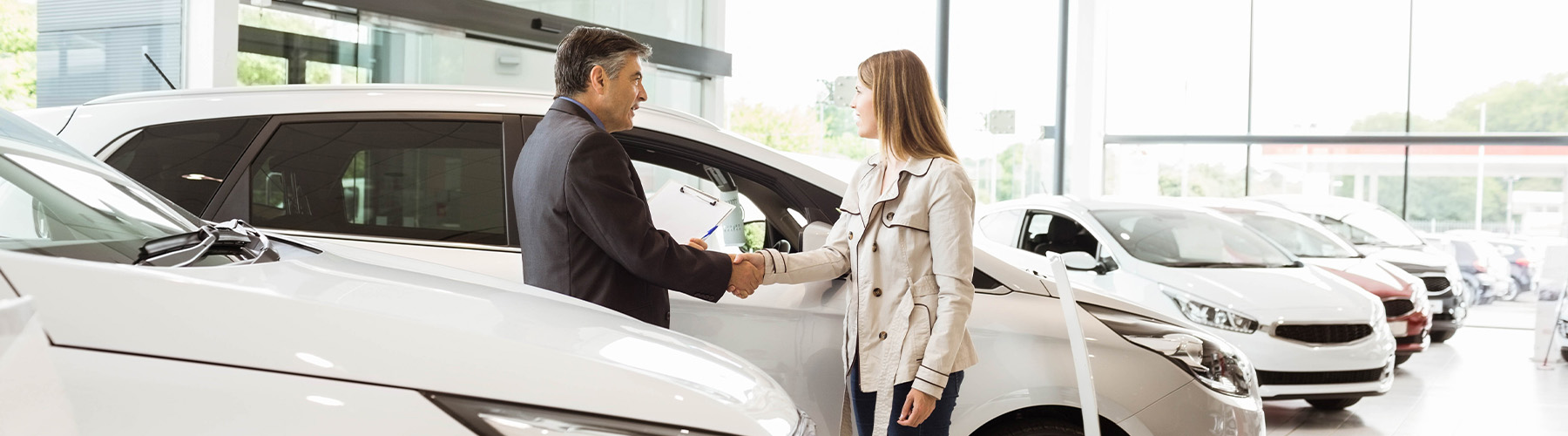 Dealership employee showing a couple a vehicle in the showroom