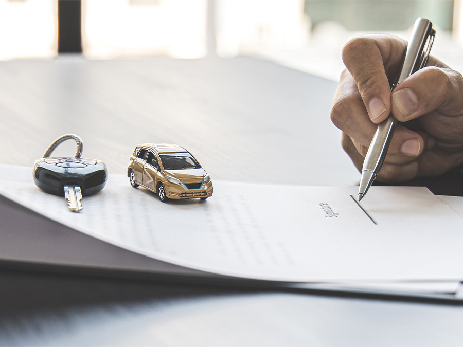 Dealership employee handing a clipboard to the customer with keys on it