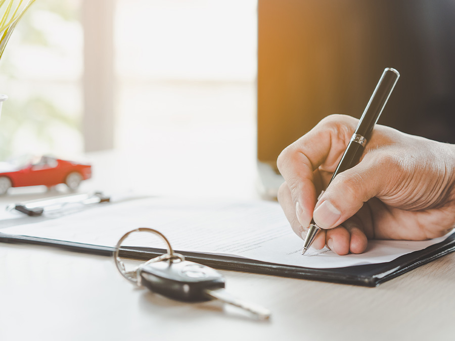 Dealership employee handing a clipboard to the customer with keys on it