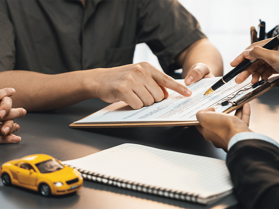 Dealership employee handing a clipboard to the customer with keys on it