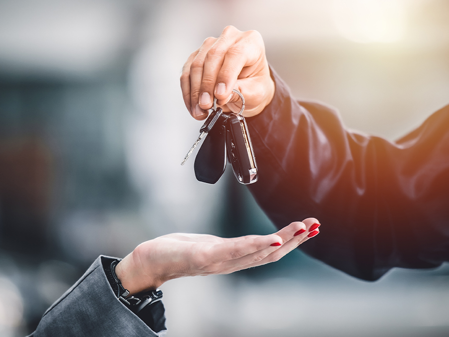 Close up of a person holding keys over a customers hand