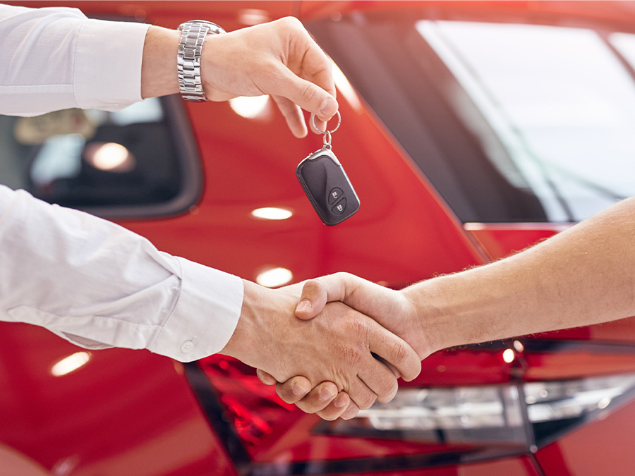 Close up of a person holding keys over a customers hand