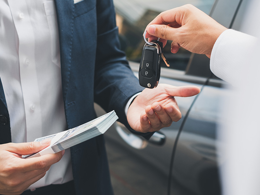Close up of a person holding keys over a customers hand