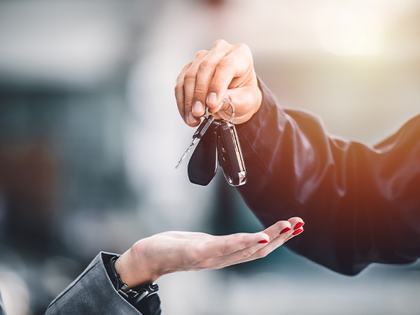 Close up of a person holding keys over a customers hand