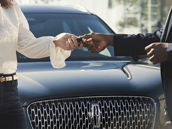 Close up of a person holding keys over a customers hand
