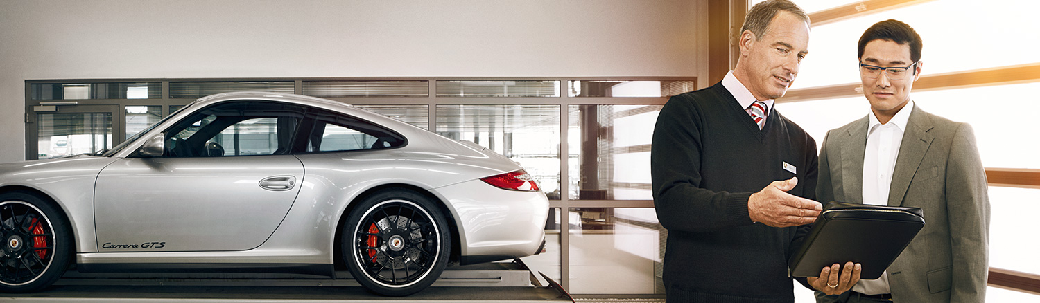 Dealership employee showing a couple a vehicle in the showroom