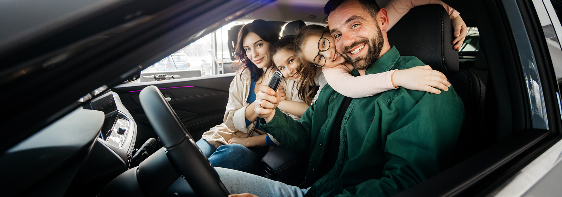 A happy young family in a modern car dealership after completing the purchase of a new family car