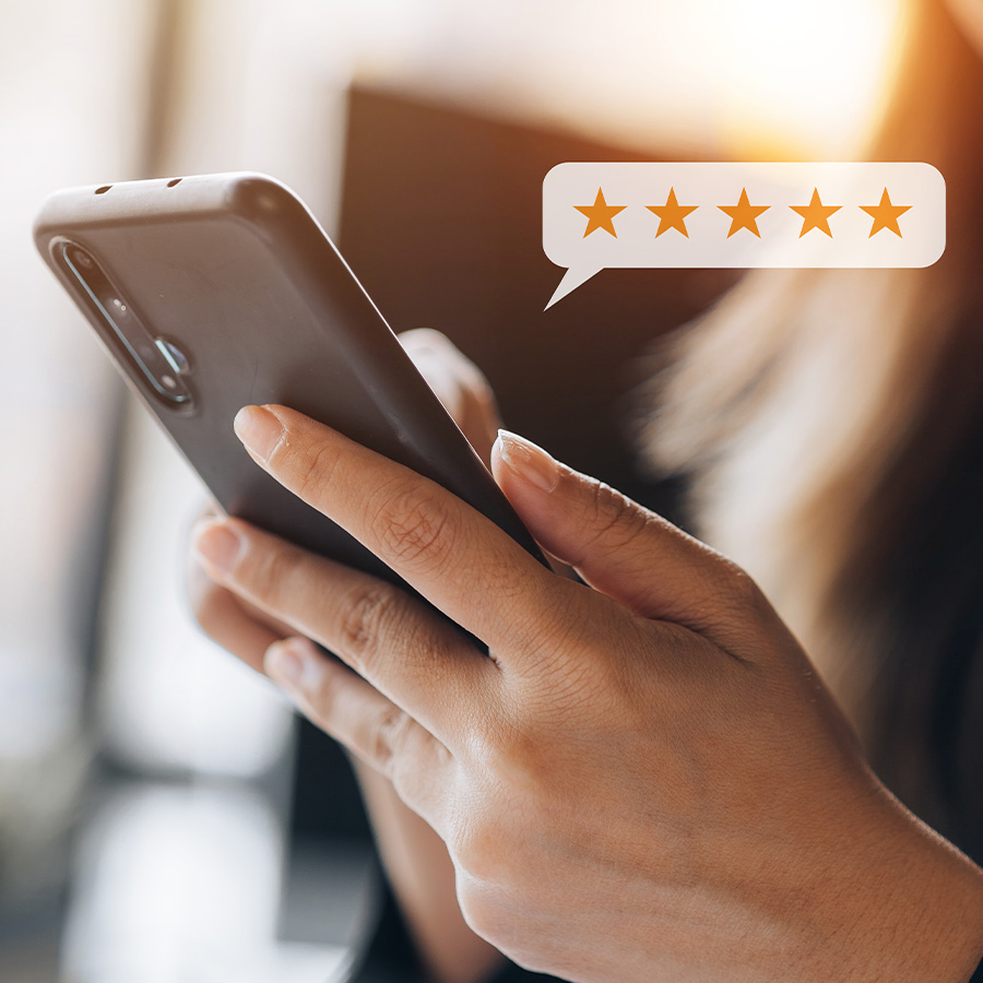Woman writting a review on her phone with a 5 Star Bubble hovering over it