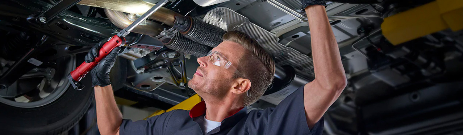 Service tech checking underneath a vehicle