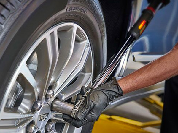 Close up of service tech rolling a tire through the service bay