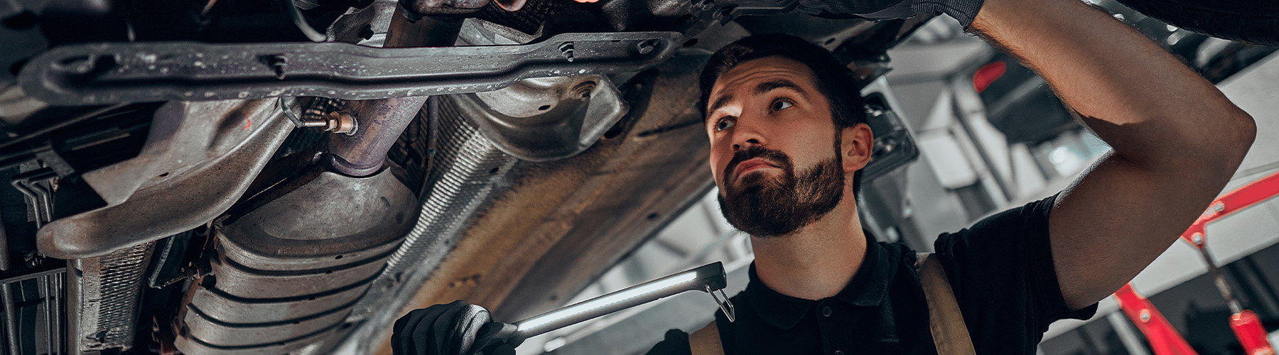 Service tech checking underneath a vehicle