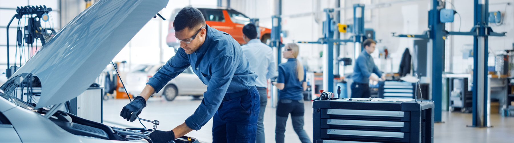 Service tech checking underneath a vehicle