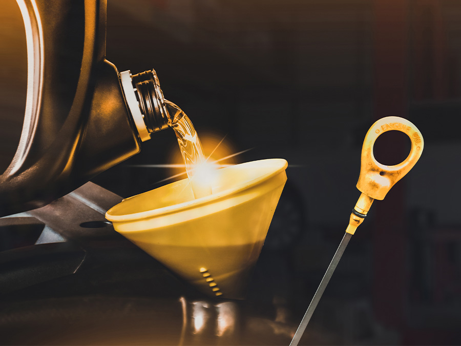 Service tech pouring oil into a vehicle for an oil change