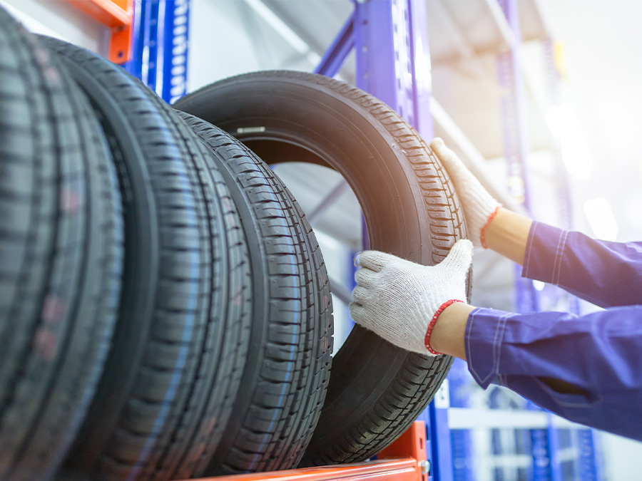 Close up of service tech rolling a tire through the service bay