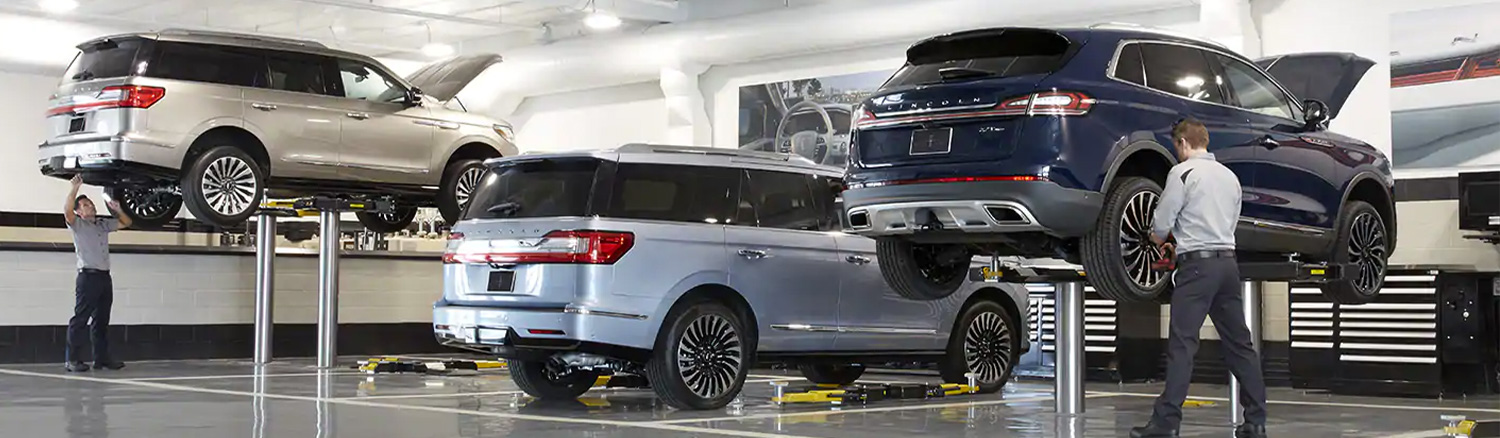 Service tech checking underneath a vehicle