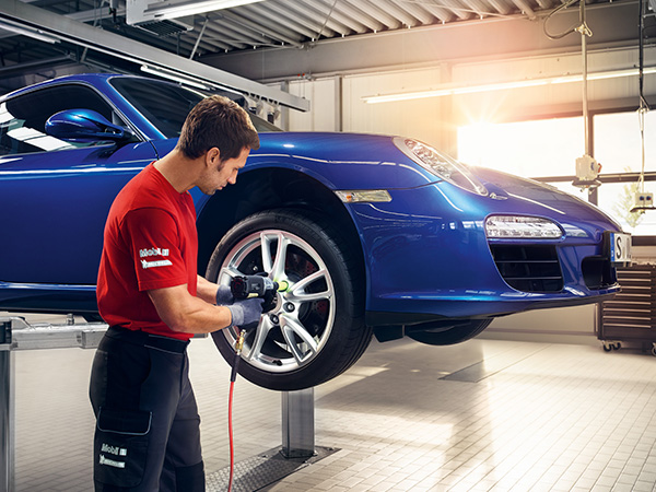 Close up of service tech rolling a tire through the service bay