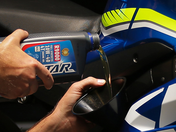 Service tech pouring oil