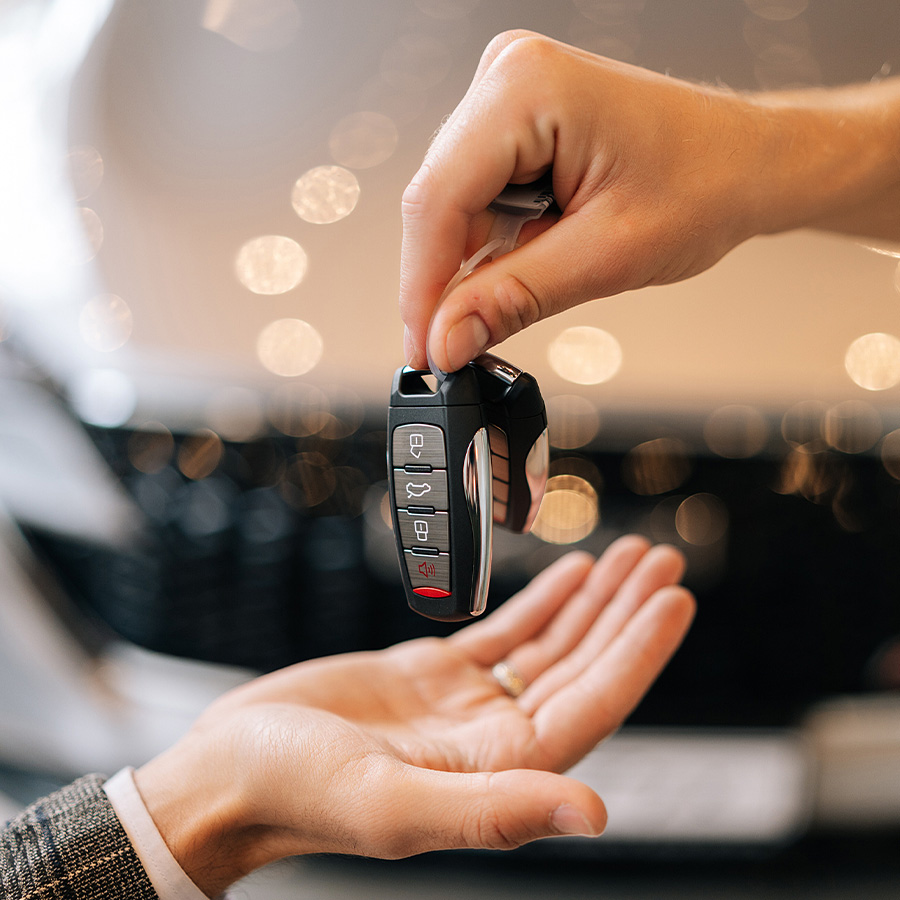 Dealership employee handing a customer keys