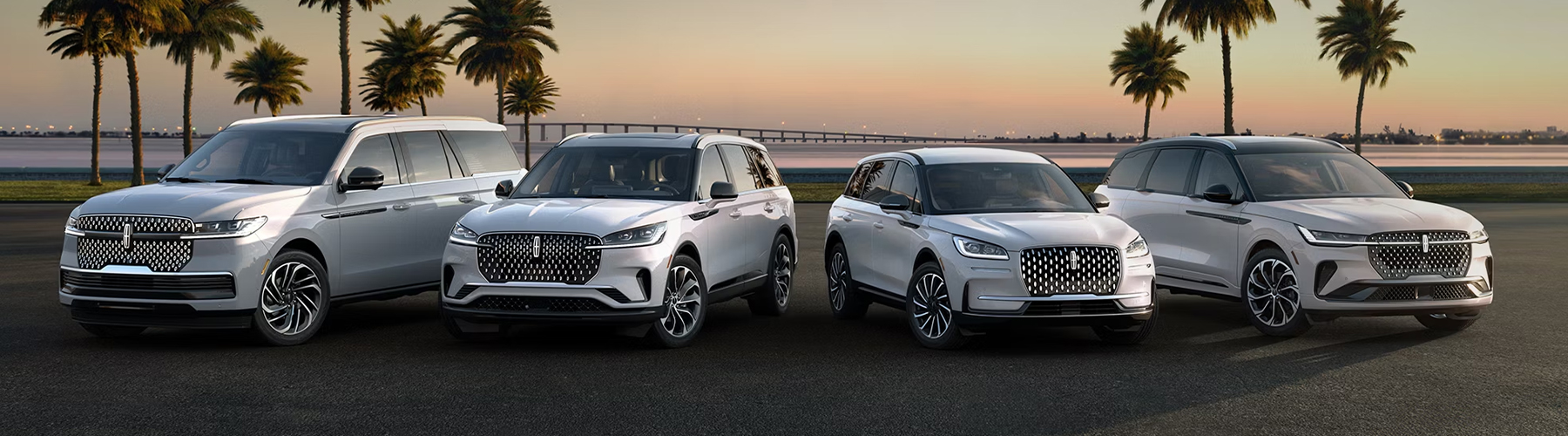 A group shot showcasing Lincoln SUVs parked in front of a body of water, with palm trees in the background.