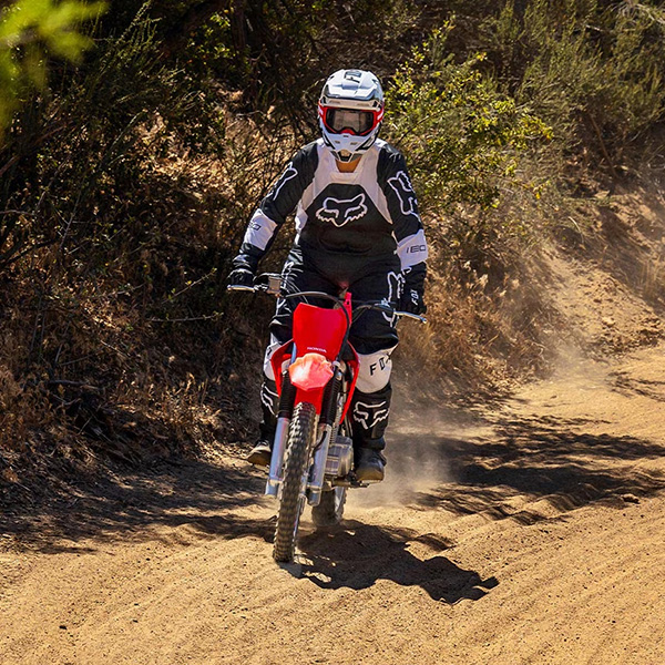 CRF125F riding on a dirt path through the woods