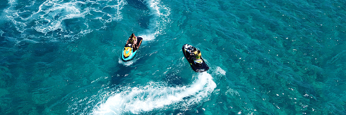 Aerial drone ultra wide photo of jet ski watercraft couple cruising in high speed in tropical exotic bay with turquoise sea