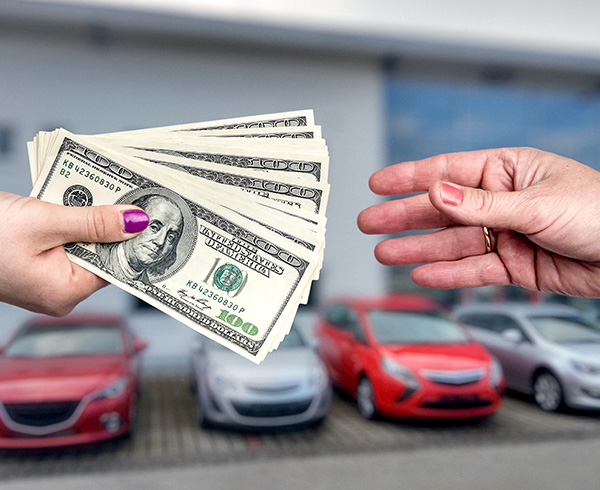 money being handed over at a car dealership