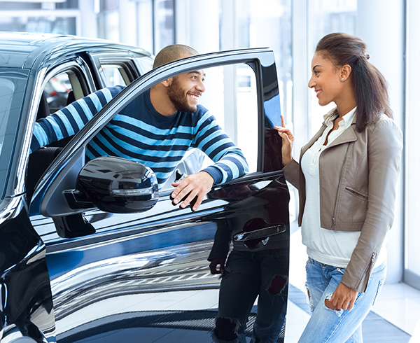 couple getting into a car at a dealership