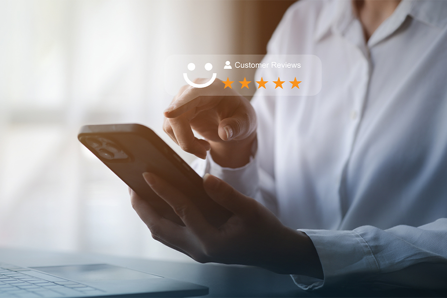 Customer leaving a positive 5-star review with a smiley face on a phone.