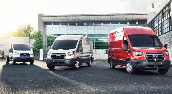Three 2023 Ford E-Transit™ vehicles parked in an industrial area