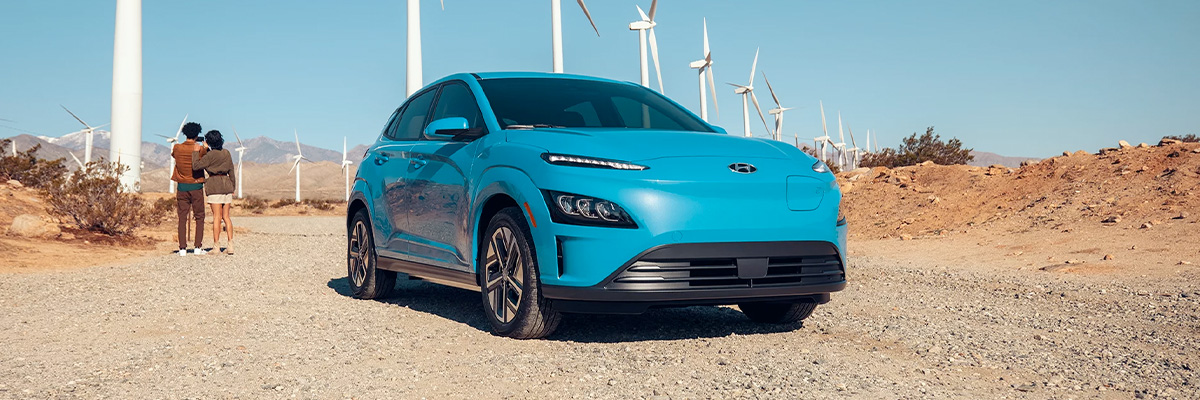 2023 Kona Electric parked in front of wind turbines