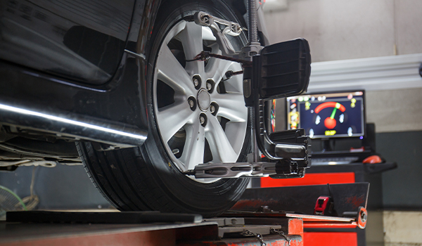 Close-up of car wheel alignment equipment and computer display.