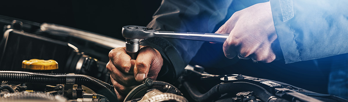 Close up of service worker working on the engine of a car