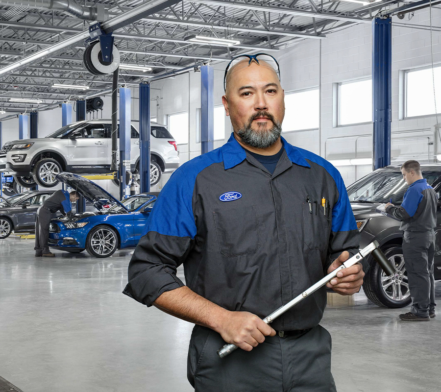 certified ford tech with wrench looking at camera