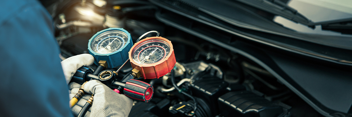 Close up hand of auto mechanic using measuring manifold gauge check the refrigerant and filling car air conditioner for fix and checking for repair service support maintenance