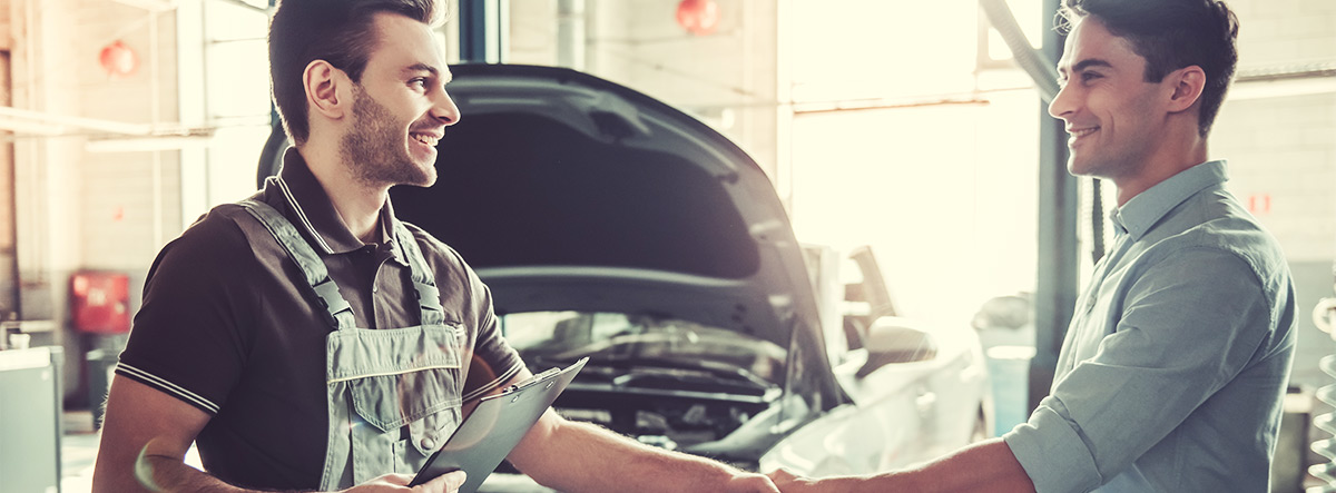 two men shaking hands in service shop