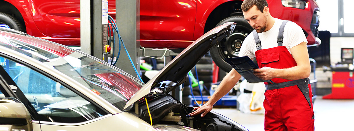 Auto car repair service center. Mechanic examining car engine