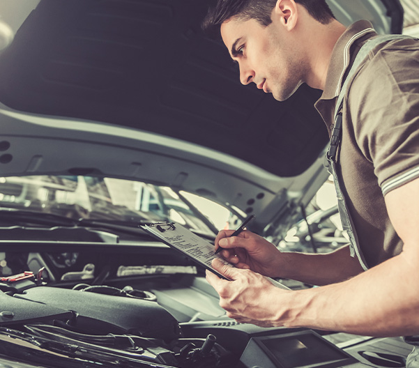 Technician inspecting car engine